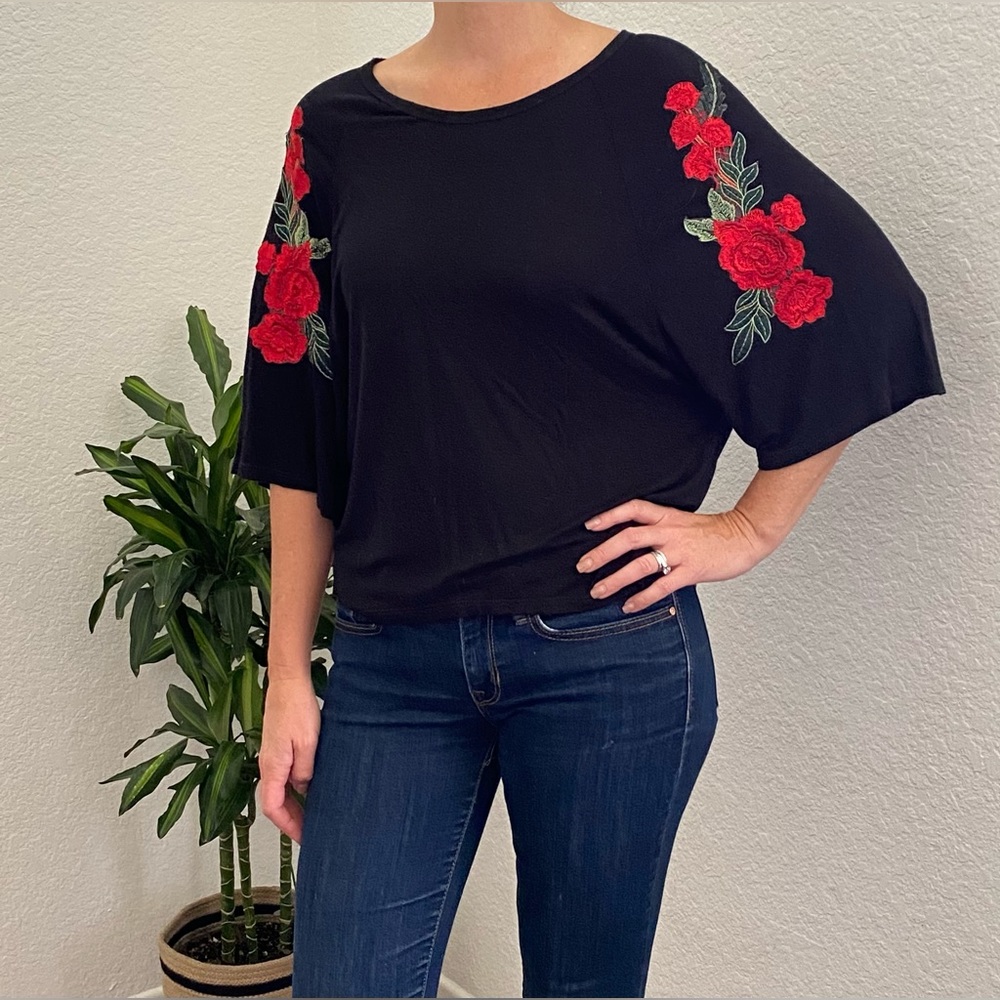 The Clas-sic black cotton blouse with floral sleeve